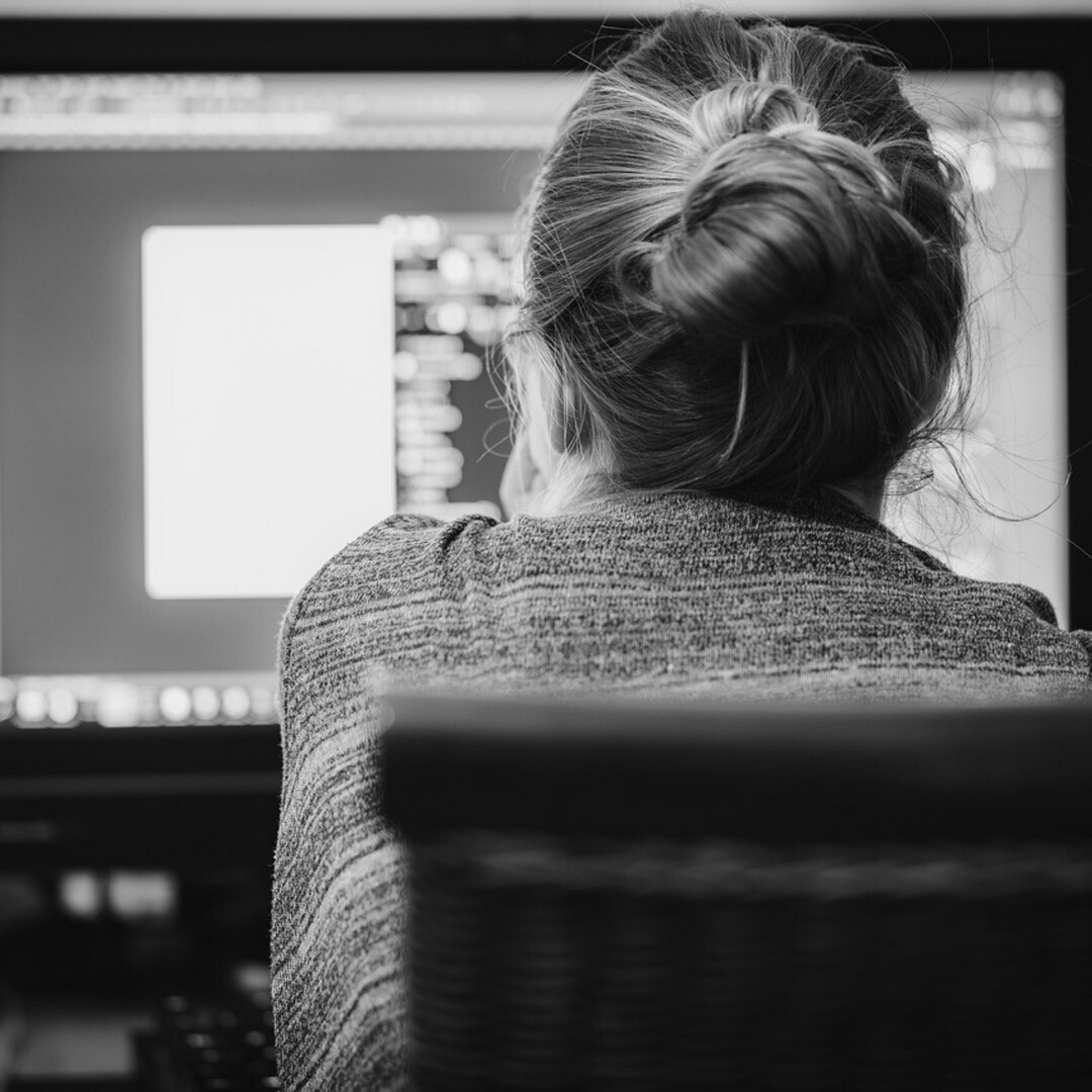 An old women sitting at a computer.