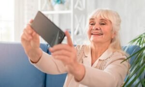 A older women using her phone to video chat.